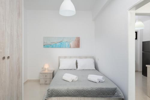 海若克利欧Rooftop Cosy Apartment Perfect Location的白色卧室配有带2个枕头的床