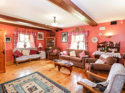 库特希尔An Maide Bán的客厅拥有红色的墙壁和木地板。
