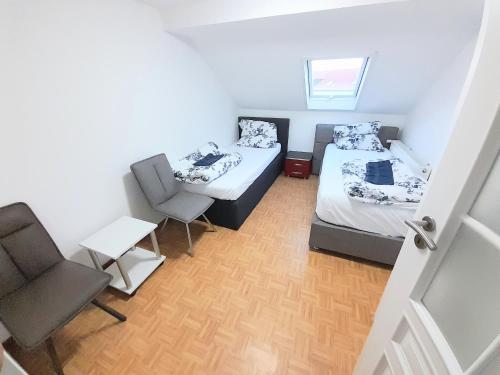 吕塞尔斯海姆FMI44Apartment的小房间设有两张床和椅子