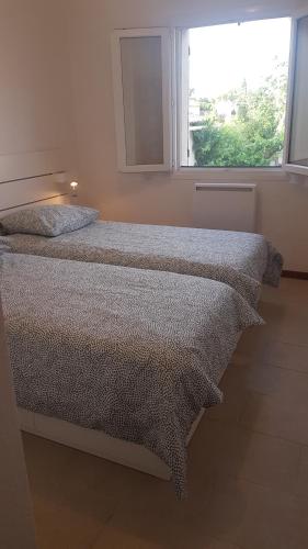 谢瓦布朗克PROVENCE, SOLEIL ET LUBERON !!! Coin jardin 3 Lits 2 Chambres 80 m2的一间卧室设有两张床和窗户。
