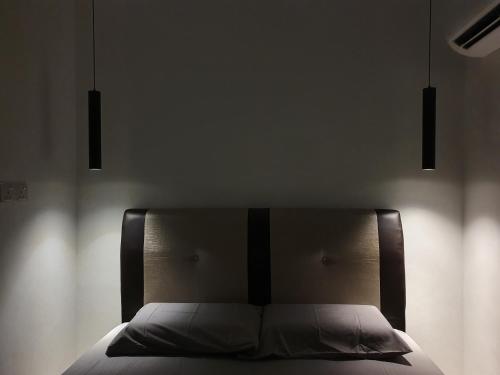 劳勿Number A Homestay的卧室内的一张床位,上面有两盏灯
