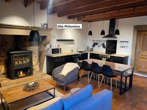 奥特里韦Les Gîtes de l'aiguete的厨房以及带蓝色沙发和桌子的客厅。