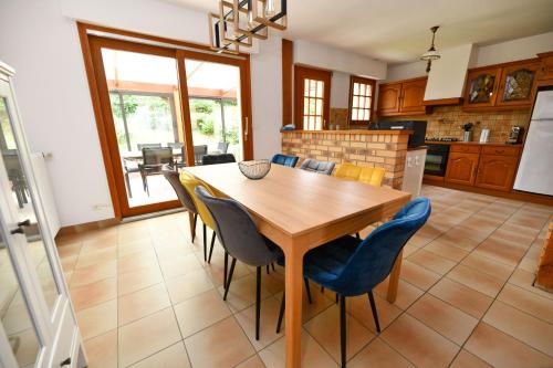 厄镇La Villa aux Oliviers的厨房以及带木桌和椅子的用餐室。