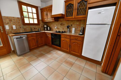 厄镇La Villa aux Oliviers的厨房配有木制橱柜和白色冰箱。