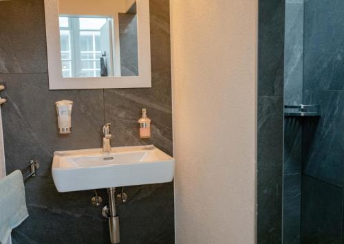 伯尔尼Stadtwohnung im Herzen von Bern mit Pool的一间带水槽和镜子的浴室