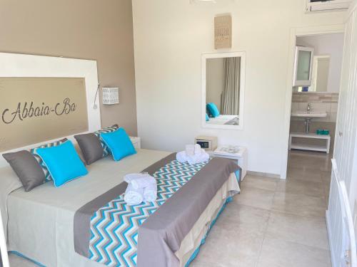 布多尼Resort Abbaia Ba的一间卧室配有一张带蓝色枕头的大床
