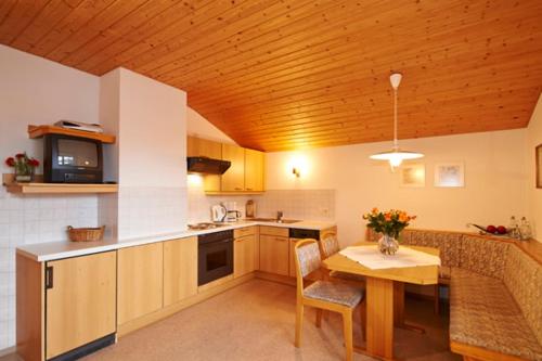 费尔兹姆斯Appartment Rettenwender的厨房设有木制天花板和桌椅
