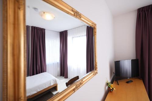 珀塞达耶Depadansa Hotel Lucija***的一张床铺和一台电视机的镜子