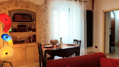 鲁蒂利亚诺Pascoli 15的客厅配有桌子和红色沙发