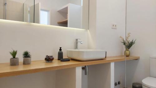 拉拉古纳Lujoso Apartamento en San Cristobal de la Laguna的木制柜台上带白色水槽的浴室