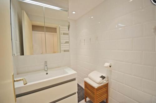 克诺克－海斯特bel appartement à 100m de la plage的白色的浴室设有水槽和镜子