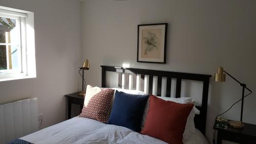 布里斯托The Cottage的一间卧室配有带色彩缤纷枕头的床。