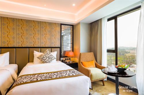巴纳内拉斯Grand Sylhet Hotel & Resort的卧室配有床、椅子和窗户。