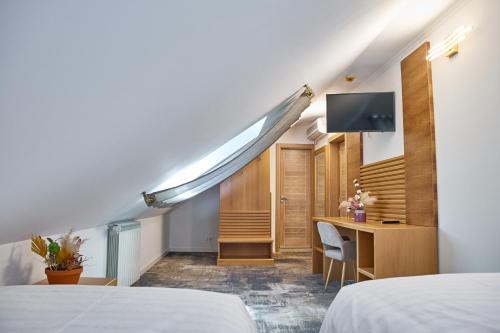 勒姆尼库瑟拉特Hotel Eden的客房设有两张床、一张桌子和一台电视机。