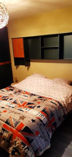 La Chapelle-lès-LuxeuilGuiguitte的卧室内一张带五颜六色棉被的床