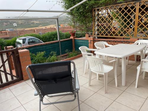 里贝拉Accogliente Appartamento Costa Makauda的庭院配有白色的桌椅和白色的桌椅