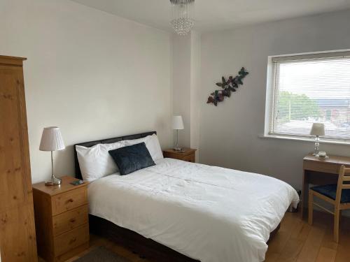 韦克斯福德韦克斯福德市中心公寓 的一间卧室配有一张床、一张书桌和一个窗户。