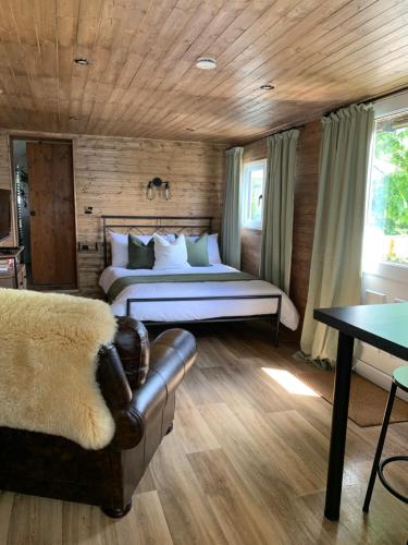 朗塞斯顿1 bedroom woodland cabin的一间卧室配有一张床和一个沙发