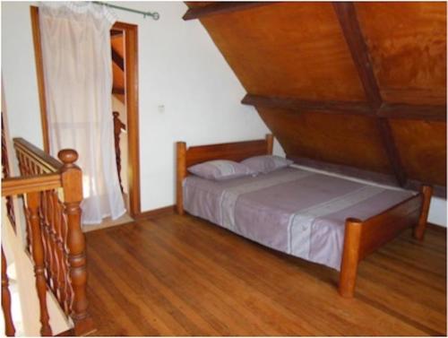 安布希德拉特里穆SNI-Village Ambohidratrimo au bord du Lac Andranotapahana的一间卧室配有一张床,铺有木地板