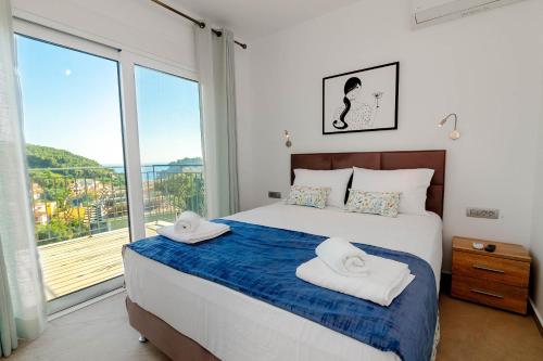 帕尔加Natura Luxury Suites Parga的一间卧室设有一张床和一个大窗户