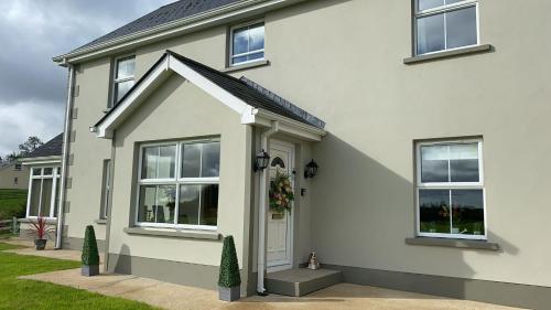 LetterbreenCorraglass House - close proximity to Cuilcagh的白色的房子,有白色的门和窗户