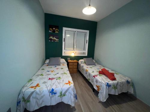 罗萨里奥港Bed & Breakfast Descanso y Relax的绿墙客房内的两张床