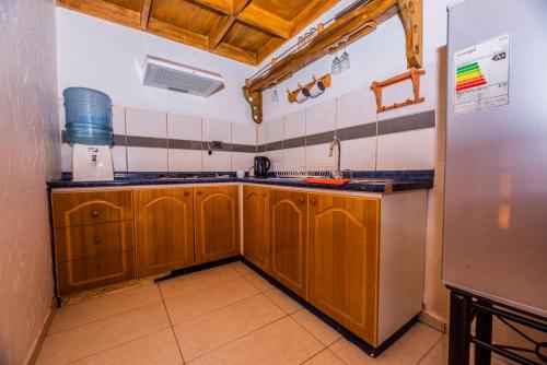 圣佩德罗·德·阿塔卡马Hotel Parina Atacama的厨房配有木制橱柜和冰箱。