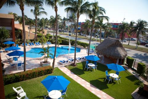 韦拉克鲁斯雅拉瓜酒店的享有带椅子和遮阳伞的度假村游泳池的空中景致
