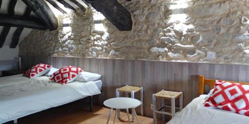 PaúlesAlbergue El Condor的一间设有两张床和石墙的房间