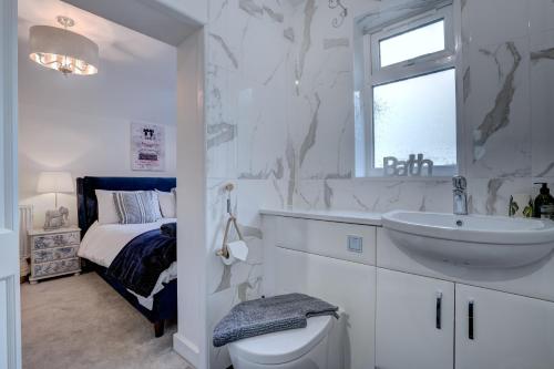 赫彻姆Norfolk Holiday Cottage 4-Bed Luxury Dog friendly的白色的浴室设有水槽和卫生间。