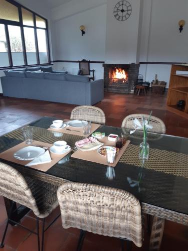 卡米尼亚Casa do Coura的一间带桌椅和壁炉的用餐室