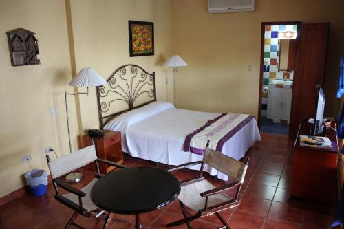 埃斯特利Hotel Los Arcos的卧室配有一张床和一张桌子及椅子