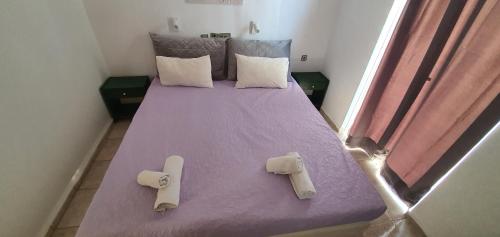 库基尼坎尼奥斯特拉公寓的一间卧室配有一张带两个枕头的紫色床