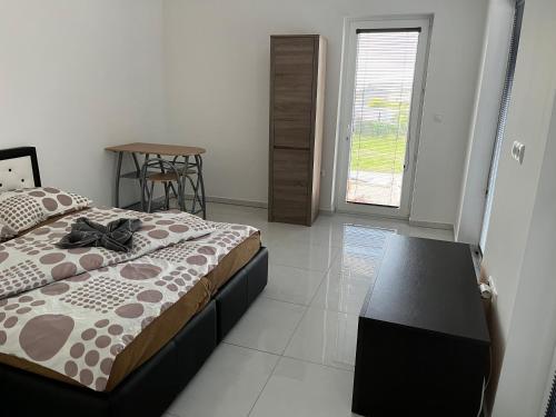 什图罗沃Apartmány Dimitra 2的一间卧室配有一张床、一张桌子和一个窗户。