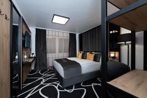 多特蒙德Hotel Unique Pearl的配有一张床和一张书桌的酒店客房