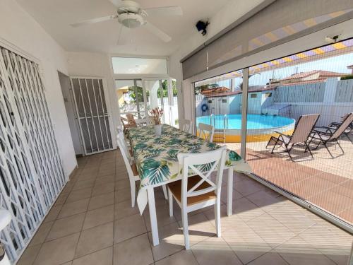 托里代巴拉Torredembarra cosy, well equipped house, 5 min. from the beach的一个带桌椅的阳台和一个游泳池