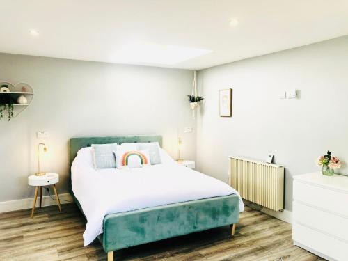韦德布里奇Detached, peaceful, spacious with easy access and very large garden的一间卧室配有一张带绿色床头板的床