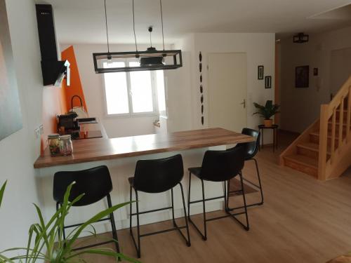 佩皮尼昂Villa perpignanaise的厨房配有木台面和黑色凳子
