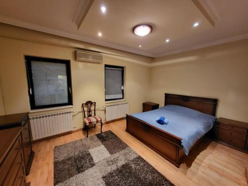 斯科普里EDEN Residence的一间卧室配有一张床、一张书桌和两个窗户。