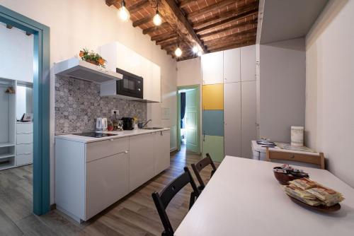佛罗伦萨Florence David's Guesthouse的厨房配有白色橱柜和桌椅