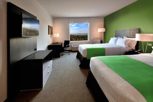马那瓜马那瓜快捷假日酒店的酒店客房设有两张床和窗户。