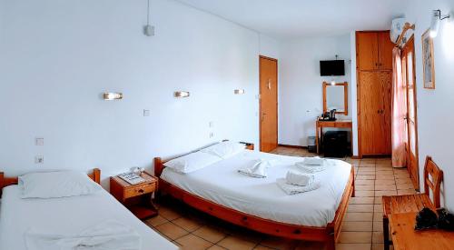 普利瑙港湾菲罗克斯尼尔酒店的客房设有两张床、一张桌子和一台电视机。