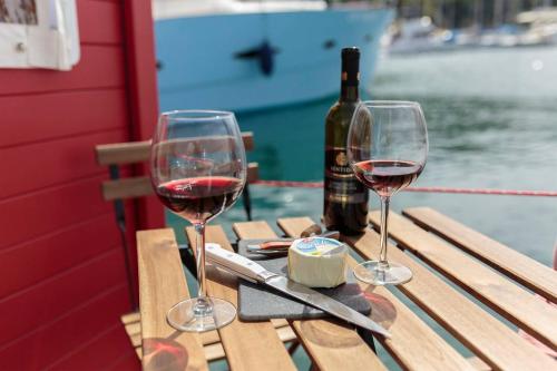 PoettoHouse boat R al Poetto 2 pax piu' 1的两杯红酒坐在野餐桌上