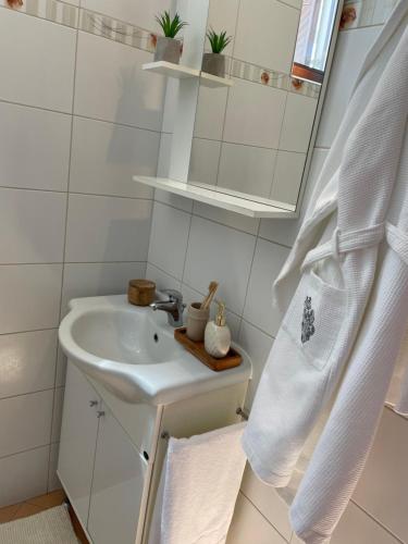 普拉Lav apartments, free parking & WiFi的白色的浴室设有水槽和镜子