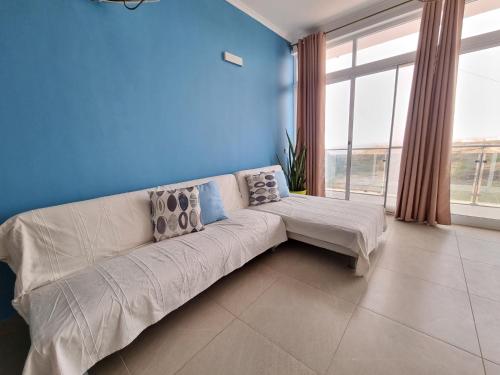 普拉亚Appartement Cara do Mar的客厅配有白色沙发和蓝色的墙壁