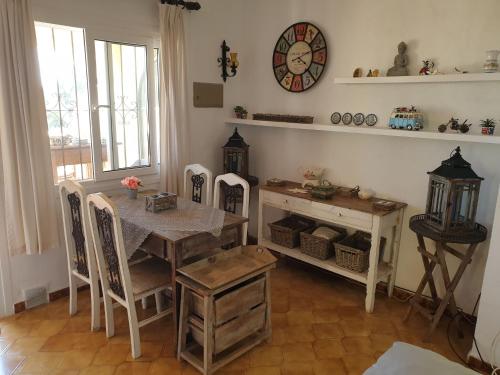 莫莱拉Belvilla by OYO Casa Kola的一间设有桌子和墙上时钟的餐厅