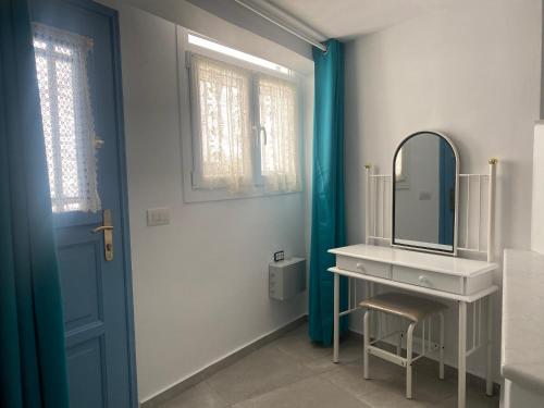 提诺斯BIANCO BLUE的一间带水槽和镜子的浴室以及一扇蓝色的门