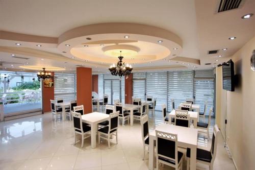 圣金Hotel Comfort的餐厅配有白色的桌椅和吊灯