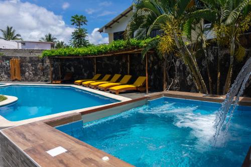 阿约拉港Hotel Las Ninfas的一个带椅子的游泳池以及一个喷泉