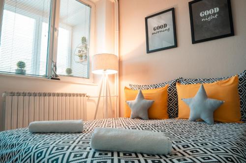 比托拉NOA Luxury Apartment的一间卧室配有带橙色和白色枕头的床